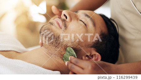 Facial, beauty and man with gua sha treatment for massage, spa aesthetic and skincare benefits for circulation. Guy, dermatology and therapist hand with stone tool for wellness and lymphatic drainage 116299439