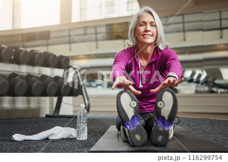 Mature woman, stretching legs and gym on floor, warmup routine or smile in portrait for workout. Person, muscle and start training for wellness with development, ready or exercise mat at fitness club 116299754