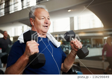Mature, happy man and weightlifting with dumbbells for fitness, workout or indoor exercise at gym. Male person with smile or earphones for strength training, muscle gain or music at health club Mature, happy man and weightlifting with dumbbells for fitness, workout or indoor exercise at gym. Male person with smile or earphones for strength training, muscle gain or music at health club 116299849
