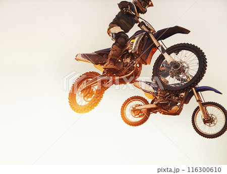Theyre neck-a-neck. A shot of two motocross riders in midair during a race. 116300610