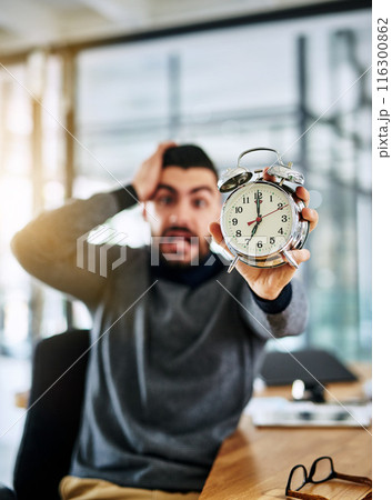 Clock, deadline and man in office with stress, pressure and frustrated in modern workplace. Businessman, time and reminder at desk for alarm, target and overworked or overwhelmed by mistake and limit 116300862