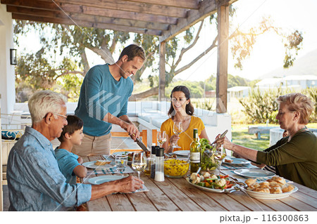 Table, food and family outdoors for lunch, supper and eating meal in backyard together. Celebration, parents and children with dish for bonding, relax and talking for nutrition, health and wellness Table, food and family outdoors for lunch, supper and eating meal in backyard together. Celebration, parents and children with dish for bonding, relax and talking for nutrition, health and wellness 116300863