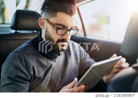 Businessman, tablet and travel in car for networking, streaming and communication in city. Connection, online and reading with technology for stock market or ebook for work and career research Businessman, tablet and travel in car for networking, streaming and communication in city. Connection, online and reading with technology for stock market or ebook for work and career research 116300907