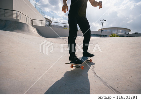 Skateboarder skateboarding at skatepark in city Skateboarder skateboarding at skatepark in city 116301291