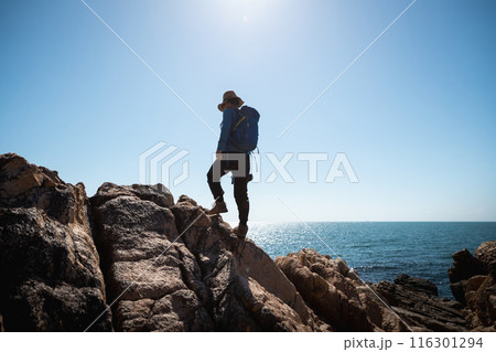 Woman photographer enjoy the view on sunrise seaside rocks 116301294