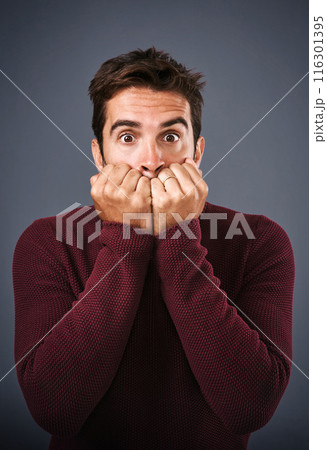 Portrait, scared and phobia of man in studio, anxiety and biting of nails for stress, afraid and fear. Gray background, mental health and person with terror for nightmare of fail in test of college 116301395