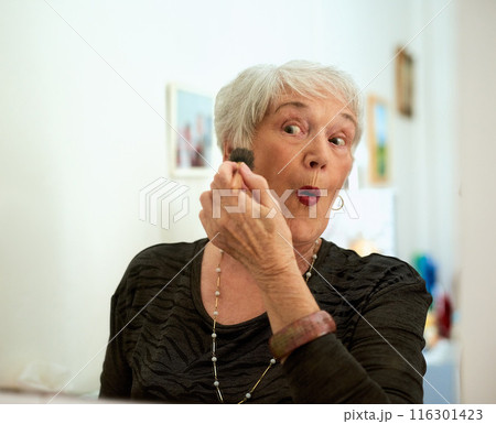Home, makeup and elderly woman with blush for beauty, wellness and surprise for facial transformation. Senior lady, happy and apply powder in bathroom with wow for cosmetic results and skin glow 116301423