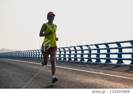 Fitness woman runner running on seaside bridge Fitness woman runner running on seaside bridge 116301669