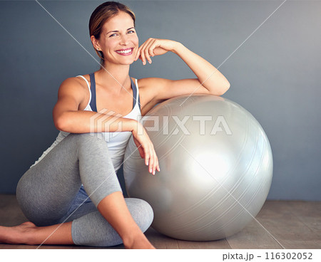 Ball, fitness and portrait of woman on floor in studio with gray background for workout. Exercise, health or smile and happy person with equipment for physical improvement, training or wellness Ball, fitness and portrait of woman on floor in studio with gray background for workout. Exercise, health or smile and happy person with equipment for physical improvement, training or wellness 116302052