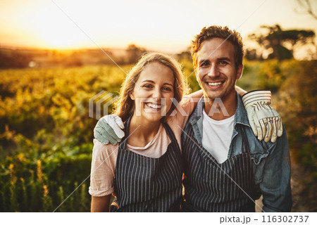 Portrait, hug and smile with couple on farm for agriculture, growth and wine. Teamwork, bonding and love with man and woman in grape field of countryside for vineyard, sustainability and environment 116302737