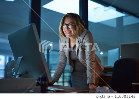 Woman, employee and smile on computer in office for internet, online and research for ideas. Female person, happy and portrait in confidence for career opportunity, growth and standing as hr at night 116303148