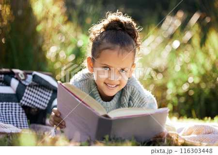 Portrait, learning and girl in a garden with book for reading, picnic and child development in nature. Smile, fantasy or happy kid with fairytale, story and literacy for studying, education or hobby 116303448