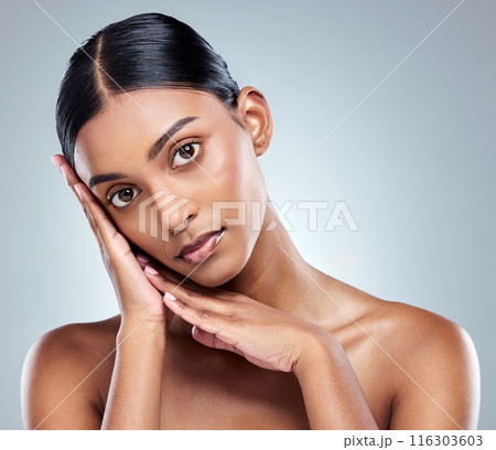 Portrait, hands and skincare in studio with Indian woman, natural beauty and skin glow on gray background. Dermatology, salon and face touch with cosmetics for glamour, spa treatment and wellness 116303603