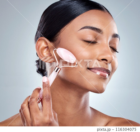 Face roller, beauty and woman in studio for skin care, wellness and product for massage. Female person, hand and cosmetics with results with glow, luxury and lymphatic drainage by white background 116304075