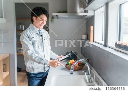 水道をチェックする水道屋・設備会社・リフォーム業者・工務店の作業服姿のビジネスマン 116304386