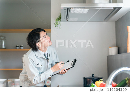 キッチンのレンジフード・換気扇を点検・チェックする作業着姿の男性ビジネスマン 116304399