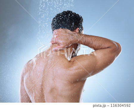 Shower, hygiene and man in studio with water splash for cleaning, grooming or shampoo on gray background. Back view, body and Asian model washing for natural treatment, wellness or morning routine 116304592