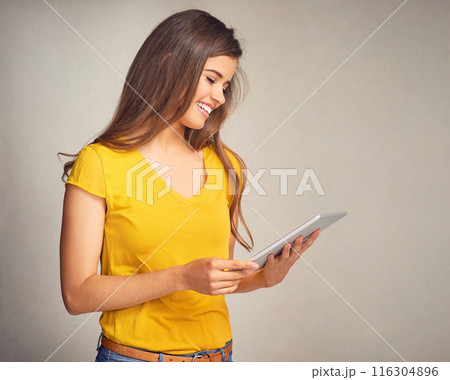 Woman, joy and browse tablet in studio background for social media, networking and communication. Female person, smile and satisfied with good news, streaming platform and website for entertainment 116304896
