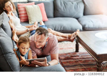 Woman, man and child with tablet as family on weekend, break at home for online gaming or movies. Happy people, lounge and relax in together for bonding as parents for growth, development and love Woman, man and child with tablet as family on weekend, break at home for online gaming or movies. Happy people, lounge and relax in together for bonding as parents for growth, development and love 116304912