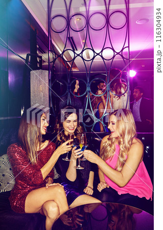 Girls, cheers and friends in nightclub with alcohol, glass or cocktails for bonding, event or reunion. Vip lounge, women and happy people in dark disco party for drinks or social celebration to toast 116304934