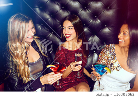 Women, toast or friends in nightclub with drink, glass or cocktails for vip, event or reunion. Happy, relax and people in dark disco party couch for fashion, alcohol or social celebration in group 116305062