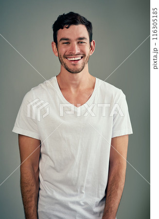 Happy, laughing and portrait of man with confidence in studio for good mood, joy and funny joke. Relax, male person and face with smile for humor, comedy meme and satisfaction on gray background 116305185