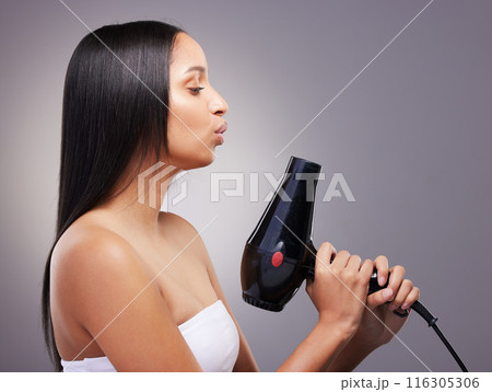 Cosmetics, woman and hairdryer in studio grey background for wellness and self care. Female person, heat treatment and equipment isolated on backdrop for salon texture, style and keratin shine Cosmetics, woman and hairdryer in studio grey background for wellness and self care. Female person, heat treatment and equipment isolated on backdrop for salon texture, style and keratin shine 116305306