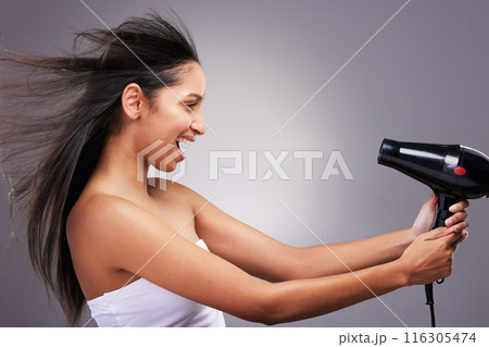 Cosmetics, woman and hairdryer wind with smile for wellness and self care in studio grey background. Female person, profile and happy with heat treatment tool for salon shine, style and keratin 116305474