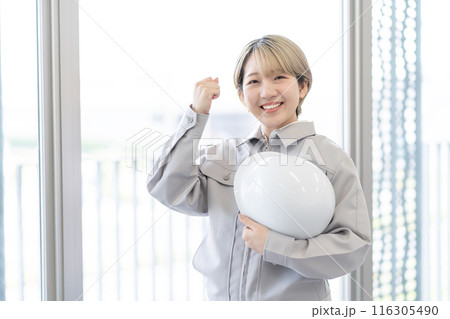 作業服を着てヘルメットを持つ金髪ショートヘアの若い女性（ガッツポーズ、髪色自由、自分らしく働く） 116305490
