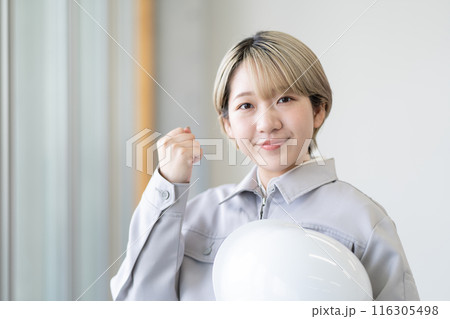 作業服を着てヘルメットを持つ金髪ショートヘアの若い女性(ガッツポーズ、髪色自由、自分らしく働く) 作業服を着てヘルメットを持つ金髪ショートヘアの若い女性(ガッツポーズ、髪色自由、自分らしく働く) 116305498