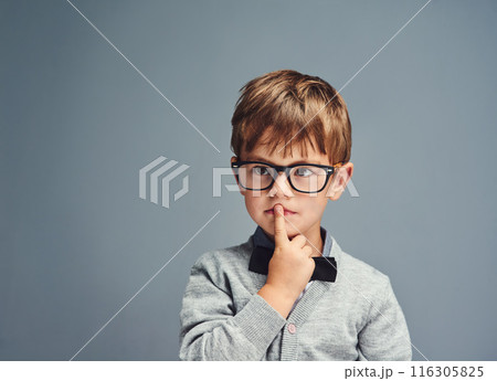 Fashion, glasses and thinking with boy genius in studio isolated on blue background for intelligence. Bowtie, idea and style with face of geek or nerd kid in trendy outfit for child development 116305825