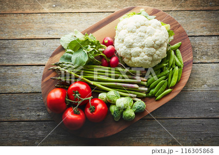 Above, desk and vegetables on wood board for cooking with diet, nutrition and healthy soup. Fresh, food and home with organic or vegetarian meal for wellness, wellbeing and self care and vegan Above, desk and vegetables on wood board for cooking with diet, nutrition and healthy soup. Fresh, food and home with organic or vegetarian meal for wellness, wellbeing and self care and vegan 116305868