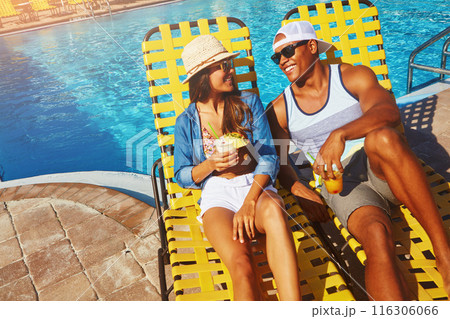 Couple, poolside and alcohol on holiday trip, outdoor and travel to hotel resort for vacation. People, peace and sunglasses by water for drinks, bonding and relax by swimming pool for wellness 116306066