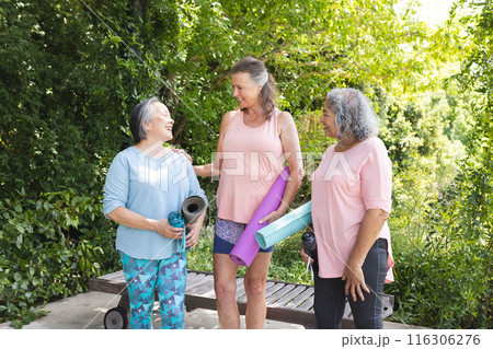 Diverse senior women, chatting outdoors, wearing casual sportswear Diverse senior women, chatting outdoors, wearing casual sportswear 116306276