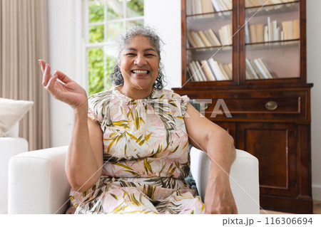 At home on video call, a senior biracial woman laughing with friends 116306694