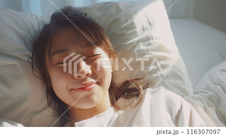 ベッドで寝ている若い女性 116307097