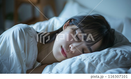 ベッドで寝ている若い女性 116307101