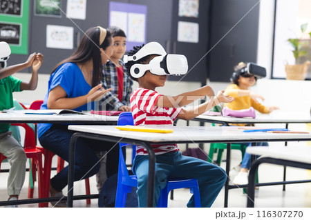 In school, diverse group of young students wearing virtual reality headsets in the classroom 116307270