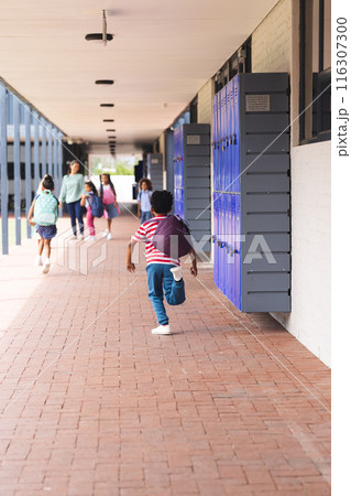 In school, diverse children are walking down hallway with lockers with copy space outdoors 116307300