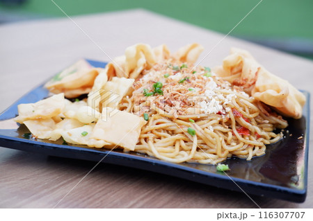 Spicy fried noodles with wonton crackers 116307707