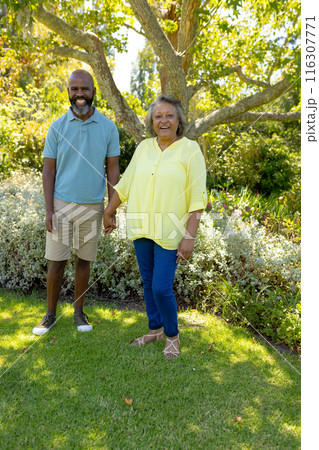 A diverse senior couple enjoying outdoors, wearing casual summer clothes 116307771