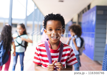 Young African American boy smiling with his backpack outdoors in school Young African American boy smiling with his backpack outdoors in school 116308746