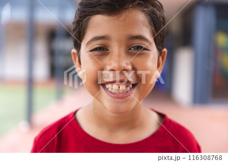 In school, young biracial male student wearing a red shirt is smiling outdoors In school, young biracial male student wearing a red shirt is smiling outdoors 116308768
