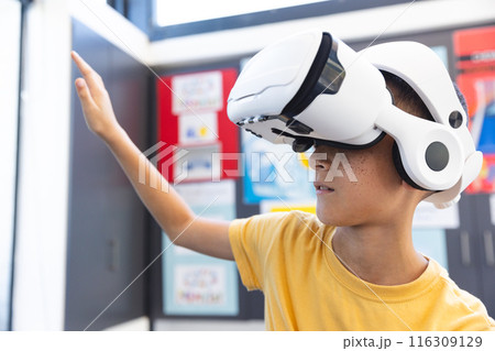 Biracial boy explores virtual reality in a school setting 116309129