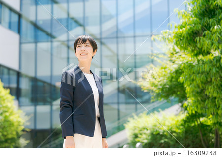 オフィスビルの前でスーツを着て立つ女性 オフィスビルの前でスーツを着て立つ女性 116309238