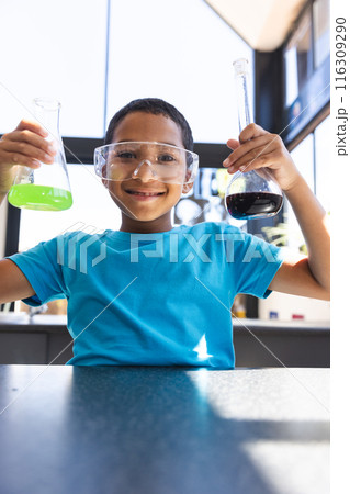 Biracial boy conducts a science experiment at school in the classroom 116309290