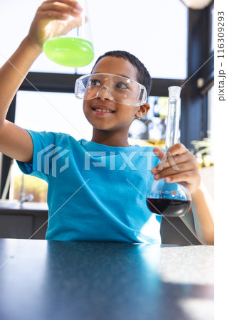 Biracial boy engages in a science experiment at school in the classroom Biracial boy engages in a science experiment at school in the classroom 116309293