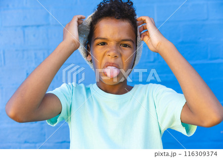Biracial boy makes a funny face outdoors Biracial boy makes a funny face outdoors 116309374