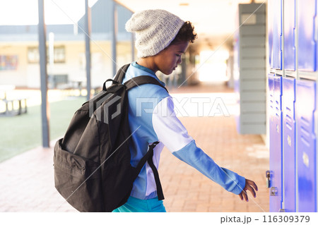 Biracial boy at school opens his locker Biracial boy at school opens his locker 116309379