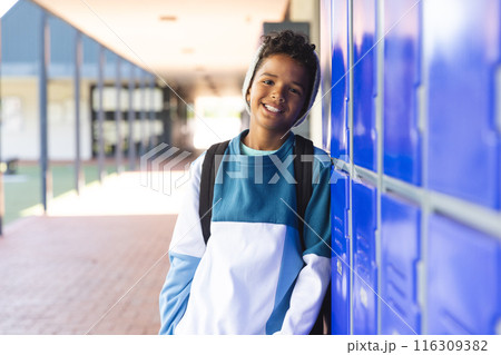 Biracial boy stands by school lockers, with copy space 116309382